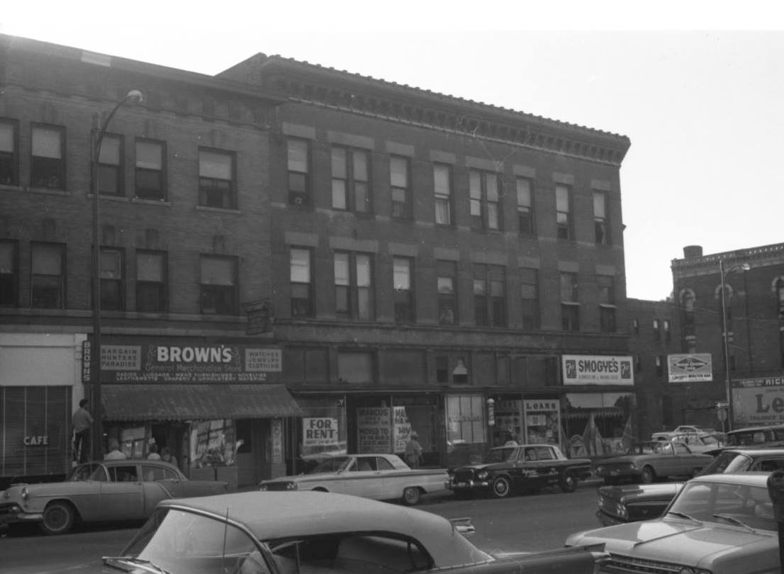 This 1960s era pic is two blocks north of Dodge Street at Davenport Street. The big building was the Wright Block Apartments at 318 North 16th Street. Also visible is Brown's Merchandise Bazaar, an empty pawn shop, Paul's Barbershop, Smogye's Groceries, and Webster's Bar on the corner. There's Richman Gordman billboard to the right, across the street from the bar.