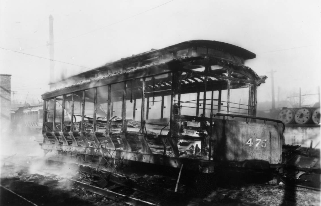 Omaha Streetcar Company car 475 lies smoldering after being demolished by rioting strikers in 1935.