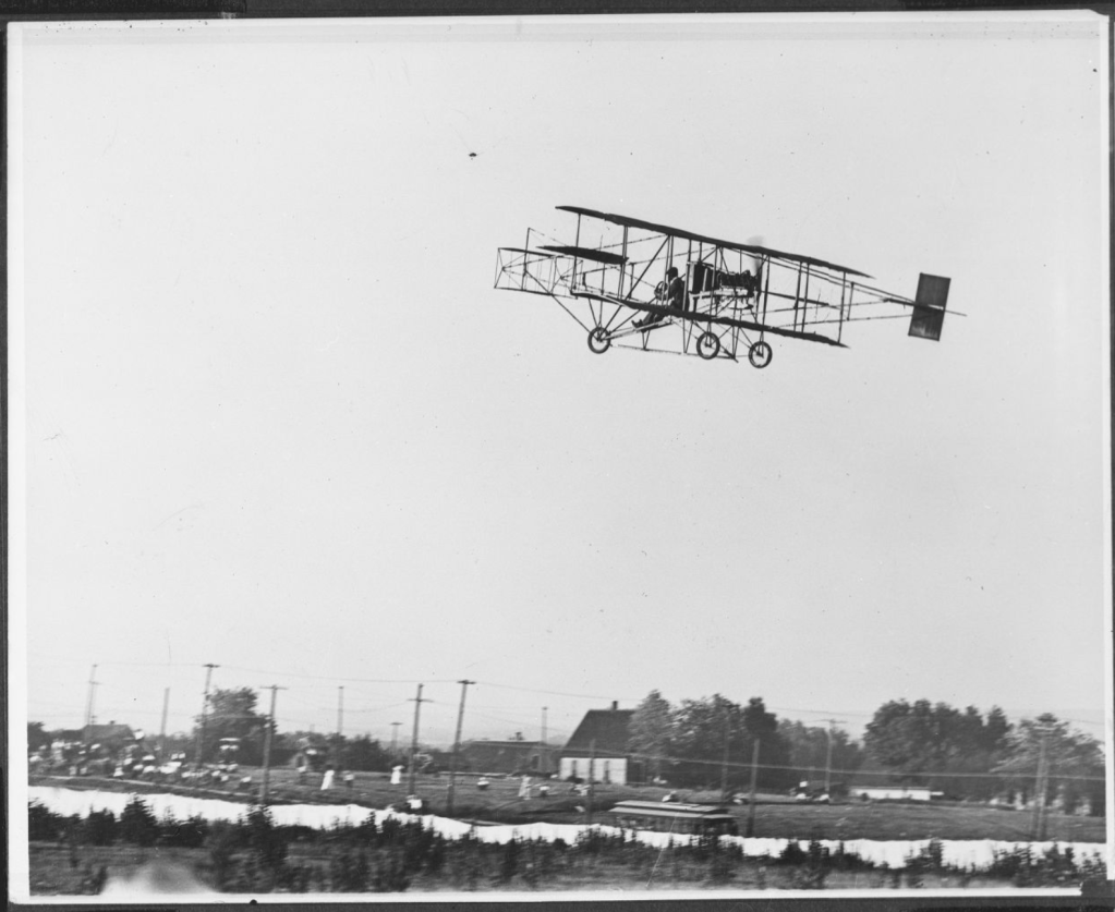 A 1910 exhibition by Glenn Curtis took off from a small airfield at N. 45th and Military Ave. The white tarp at the bottom of this pic is a visual barrier so non-paying viewers (gathered at left) couldn't see landing or taking off. Notice the top of the Benson streetcar above the tarp.